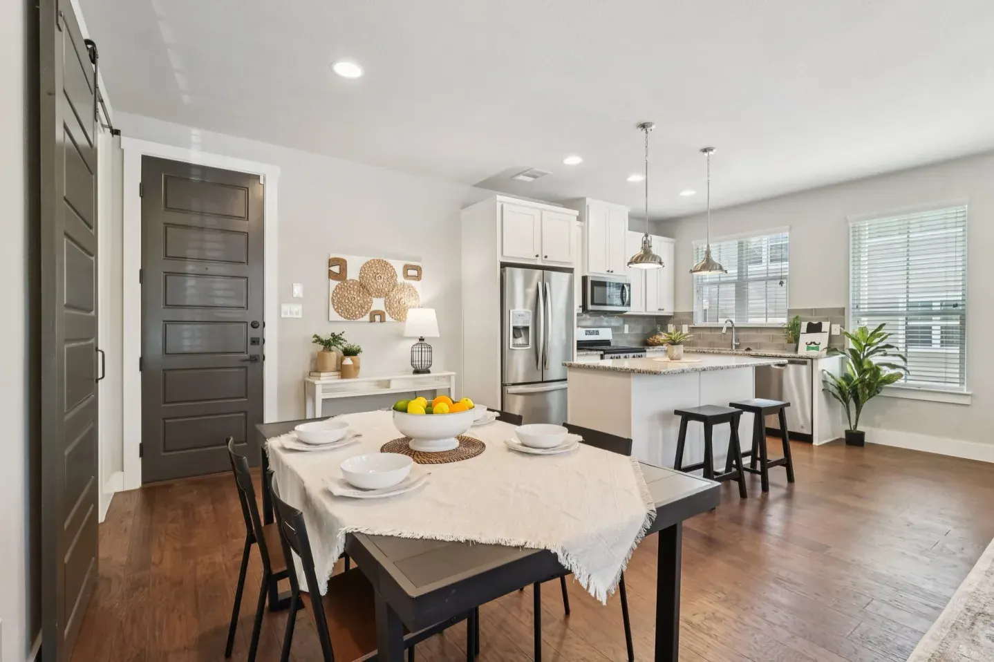 Dining table and kitchen island staged with warm neutral decor