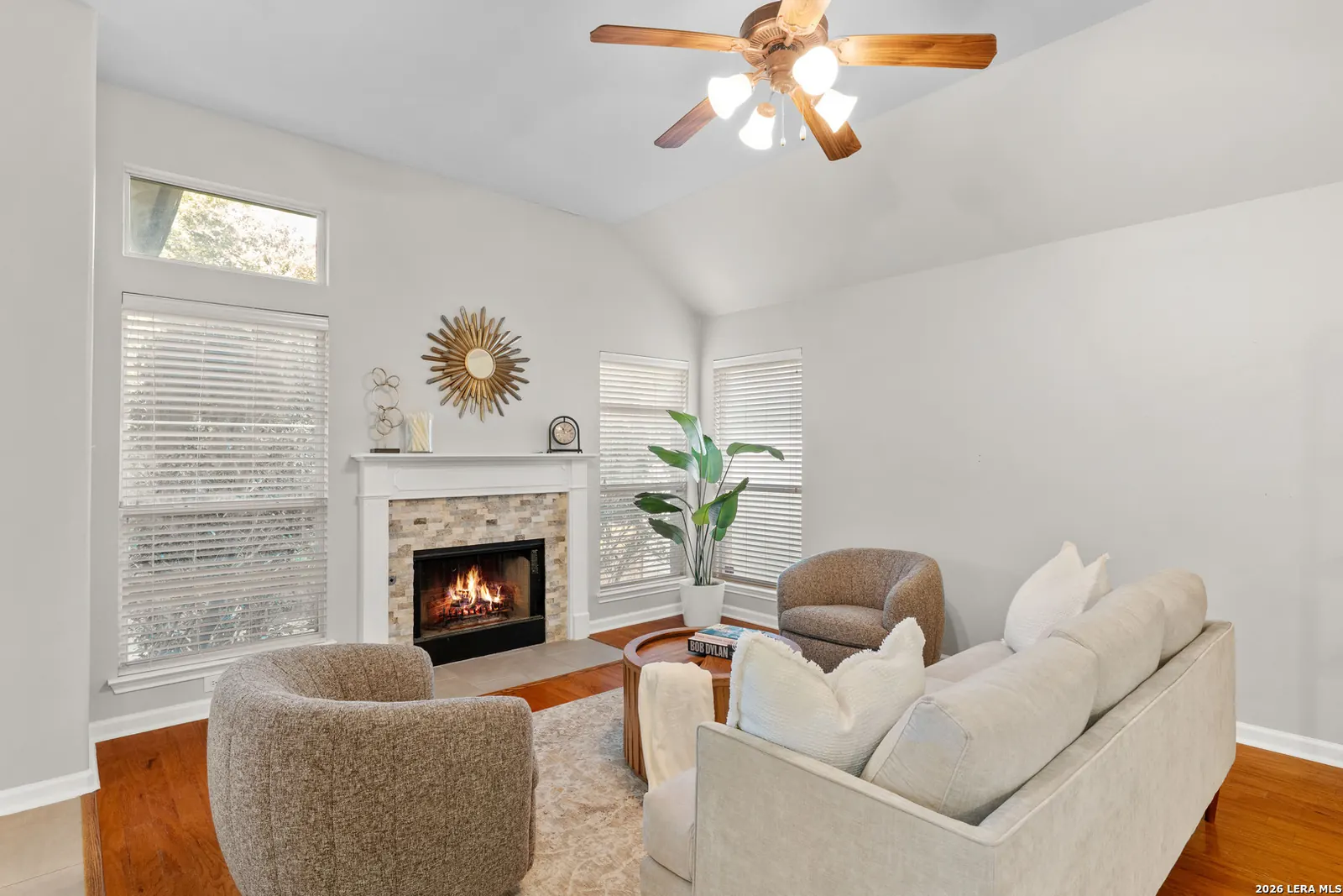 Staged living room with fireplace and neutral seating