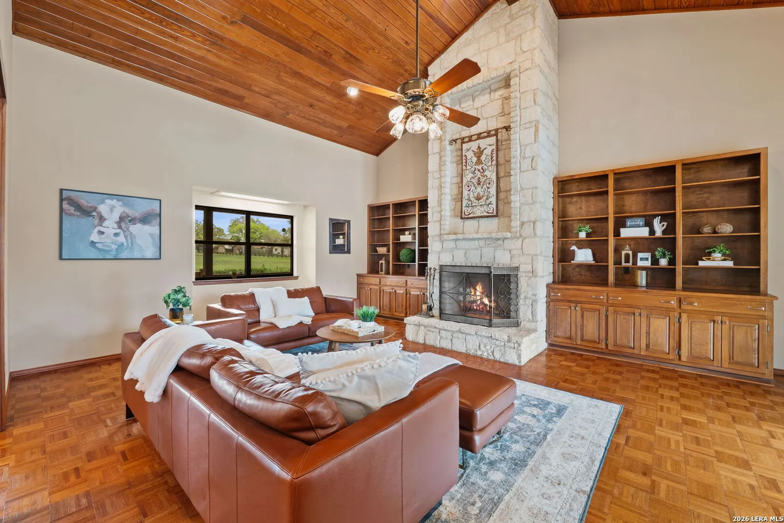 Staged living room with wood built-ins and leather seating